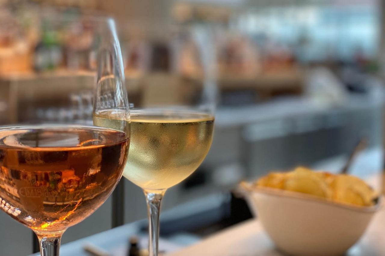 Frankfurt Airport Marriott Hotel فرانكفورت المظهر الخارجي الصورة The photo features two wine glasses placed on a table. The glass on the left contains a rosé wine, which has a pinkish hue, while the glass on the right holds a white wine, appearing pale and clear. In the foreground, there is a small bowl of snacks,
